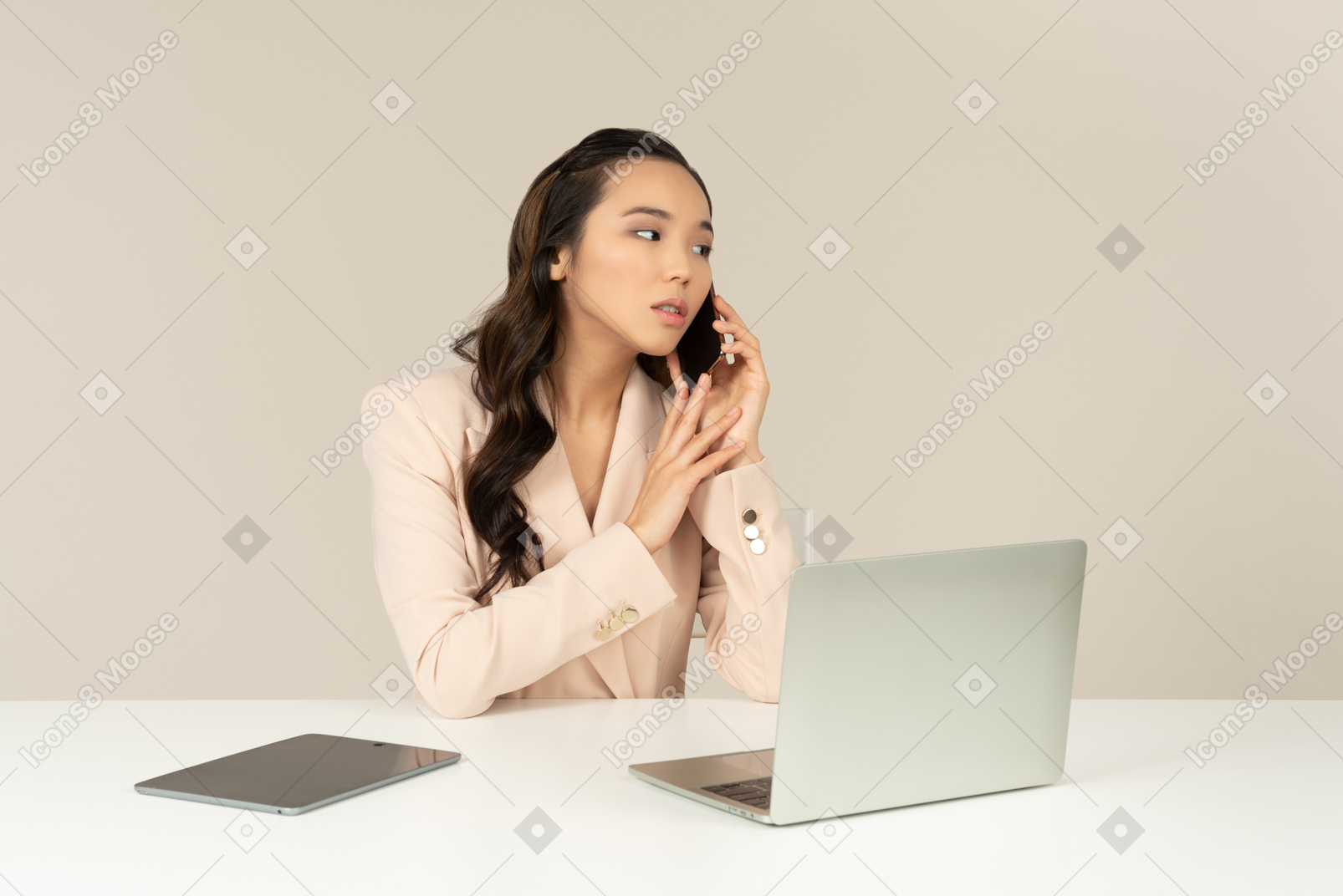 Asian female office employee listening carefully to phone call