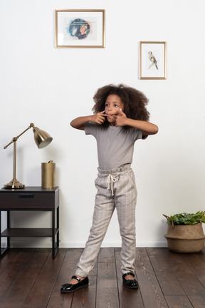 Good looking girl kid posing on the apartment background