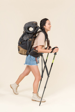 Donna escursionista a piedi con bastoncini da trekking