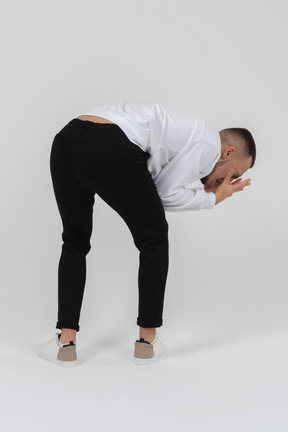 Back view of a man covering his face while bending over