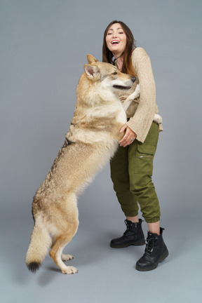 彼女の犬と遊ぶ幸せな女性マスターのフルレングス