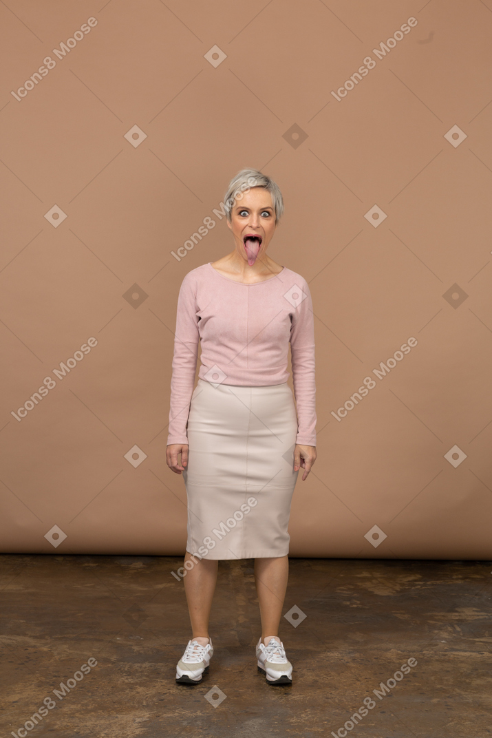 Vista frontale di una donna in abiti casual che mostra la lingua