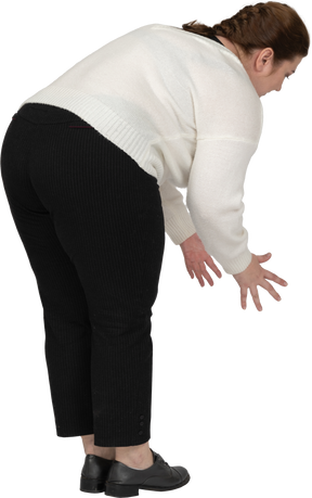 Vista laterale di una donna grassoccia in abiti casual che si piega
