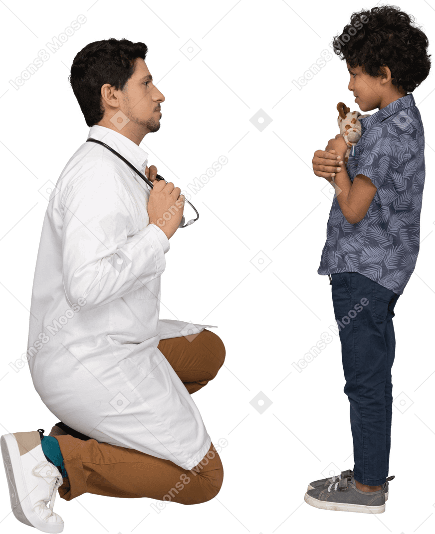 Niño sosteniendo un juguete mientras el doctor lo mira