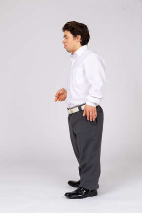 Vista lateral de um jovem em roupas casuais de negócios em pé com os olhos fechados
