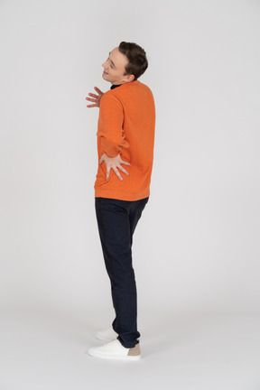 Young man in orange sweatshirt standing