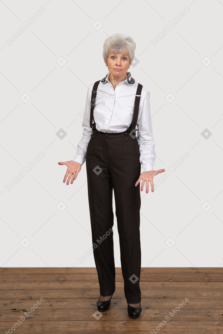 Vue de face d'une vieille dame interrogatoire gesticulant en tenue de bureau