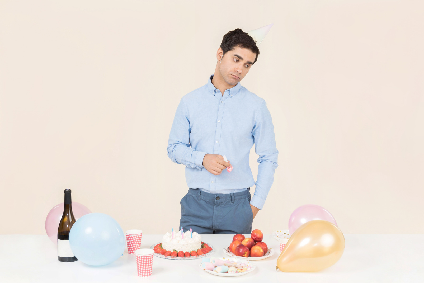 Young caucasian man standing near birthday table