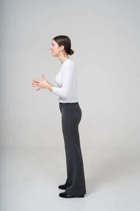Vista lateral de uma jovem com roupas casuais gesticulando