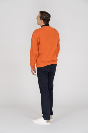 Young man in orange sweatshirt standing