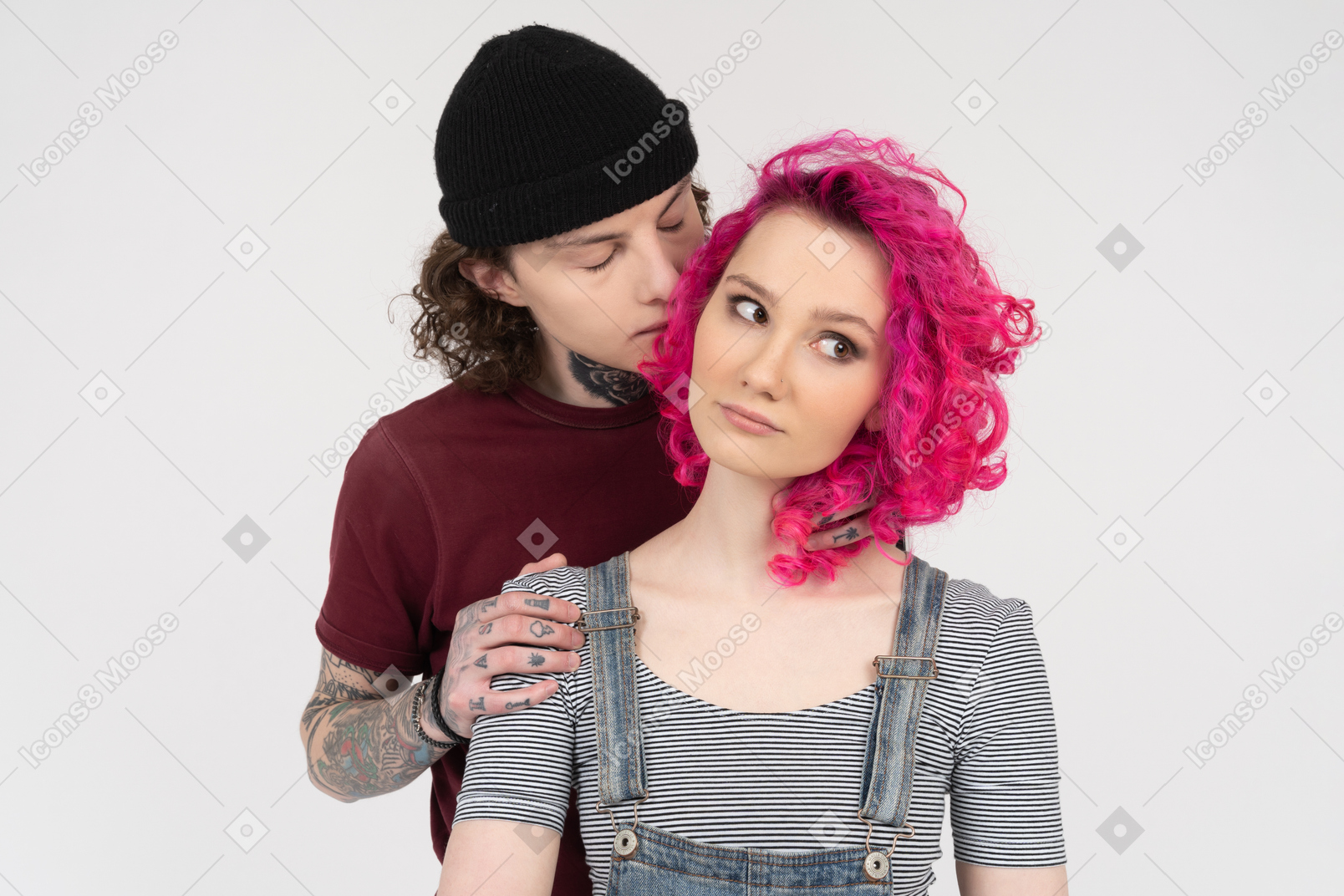 그의 여자 친구 뒤에 서있는 젊은 남자가 그녀의 뺨에 키스