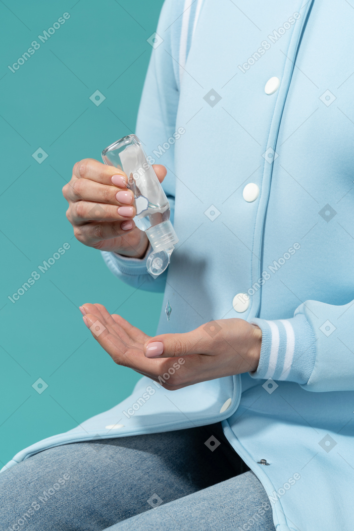 A woman using a hand sanitizer