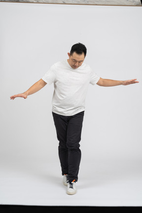 Вид спереди человека в повседневной одежде, идущего с распростертыми руками