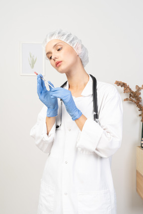 Vista frontal de una joven doctora sosteniendo una jeringa