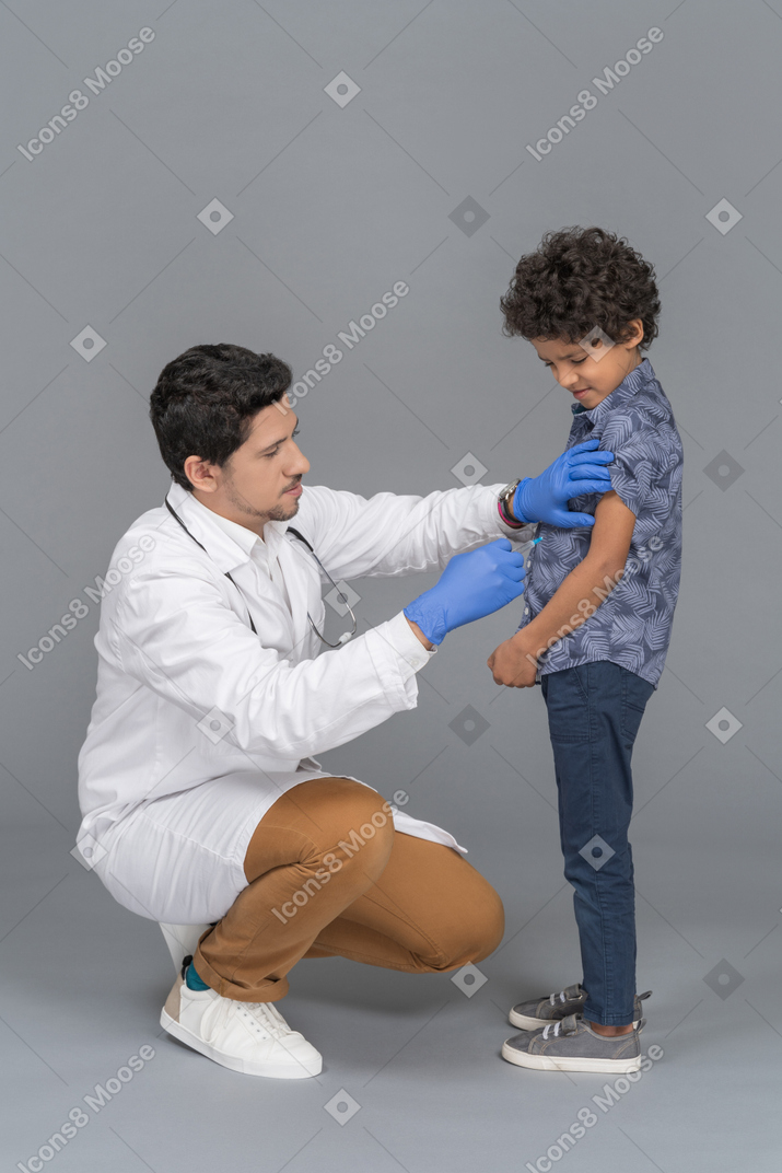 接种疫苗后的男孩和医生