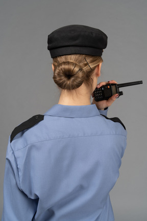 Guardia de seguridad femenina sosteniendo una radio