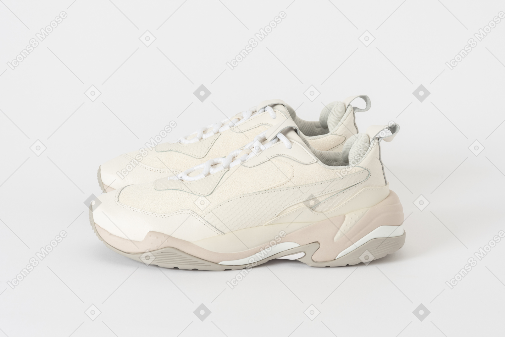 Боковой снимок пары бело-бежевых кроссовок
