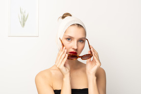 Young woman with bandaged head putting on sunglasses