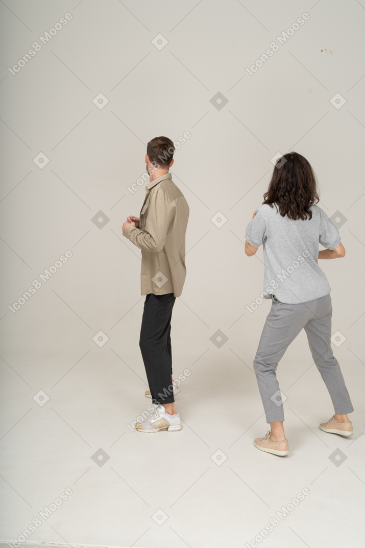 Вид сбоку на двух молодых людей, танцующих