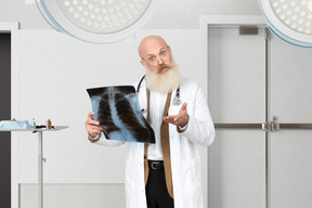 A man in a lab coat holding a x - ray