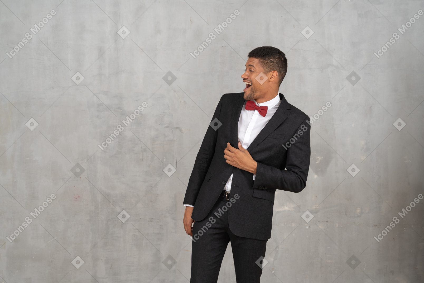 Lachender mann im schwarzen anzug, der nach rechts blickt