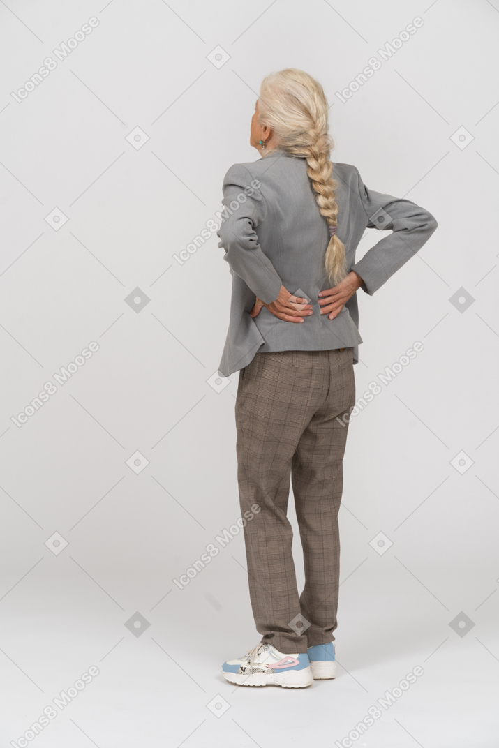 Retrovisor de uma senhora idosa de terno sofrendo de dores nas costas