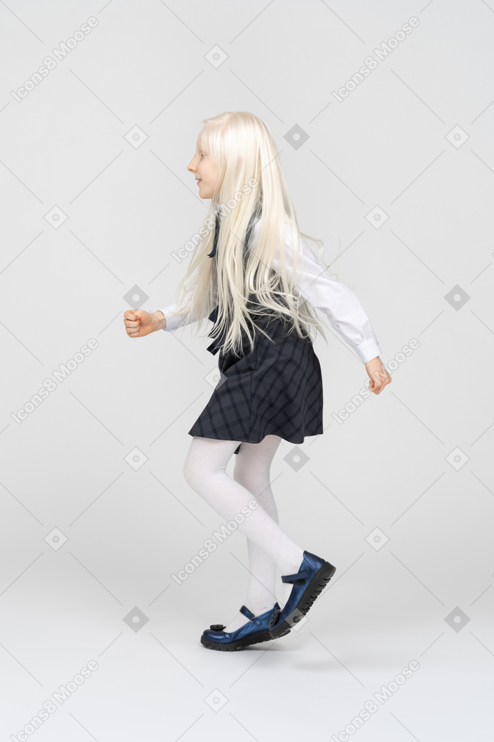 Vue latérale d'une écolière marchant