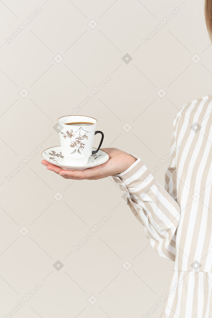 Mano femenina con taza de té
