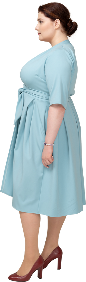 Femme en robe bleue debout de profil