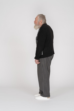 Vista laterale di un vecchio in maglione in piedi