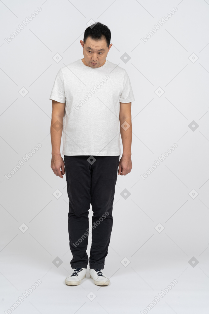 Vista frontal de un hombre con ropa informal mirando hacia abajo