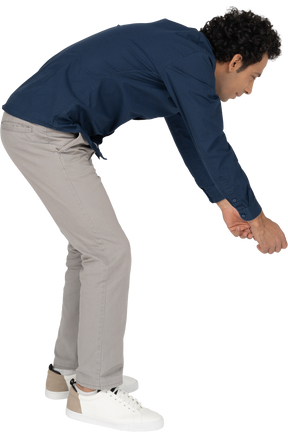 Side view of a man in casual clothes bending down