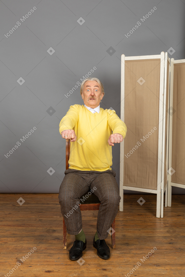 Surprised man clenching his fists and extending his arms forward