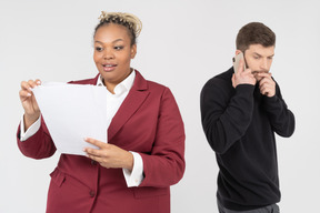 Homme parlant au téléphone pendant que son responsable vérifie les documents