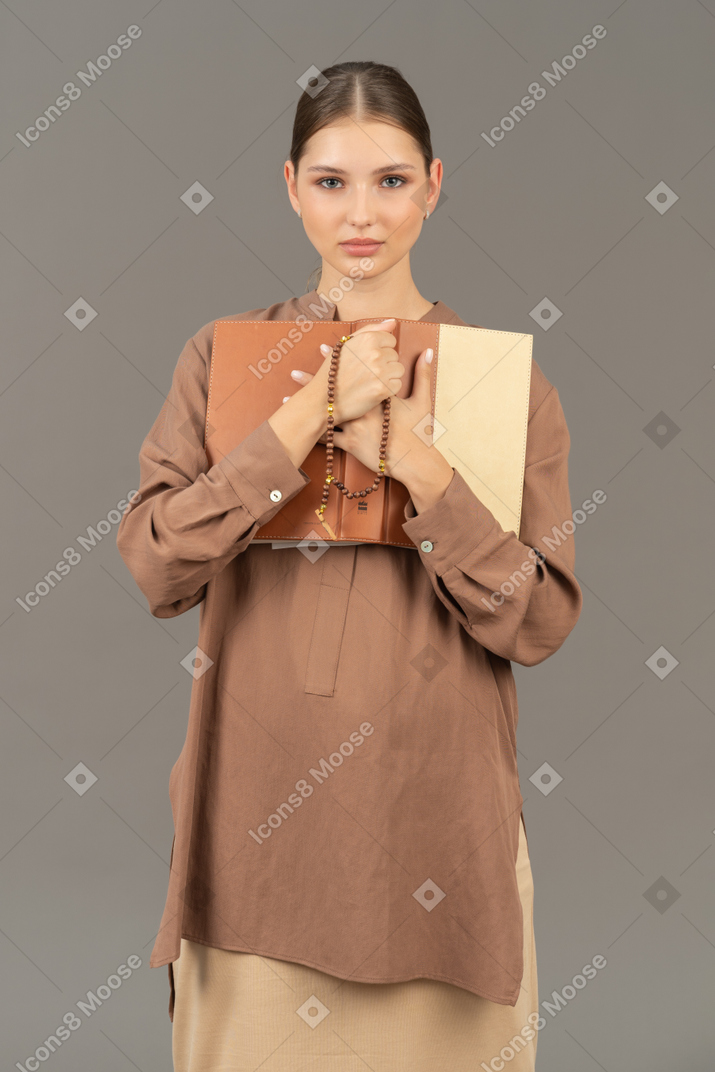 Woman holding book to chest