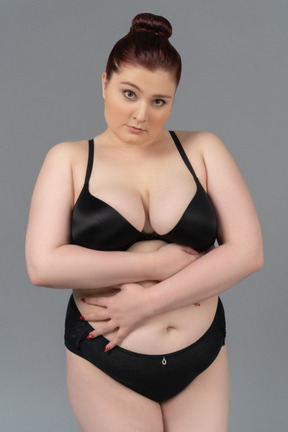 Plump caucasian female posing in black lingerie