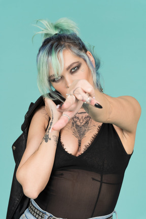 Turquoise haired punk woman pointing to camera with a finger