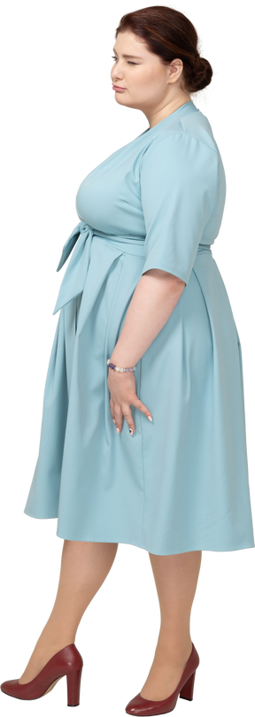 Frau im blauen kleid posiert im profil