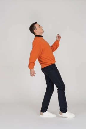 Young man in orange sweatshirt posing