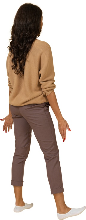 Three-quarter back view of a questioning dark-skinned young female outspreading her hands
