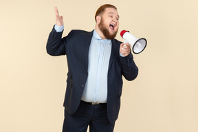 Young overweight office worker screaming using megaphone