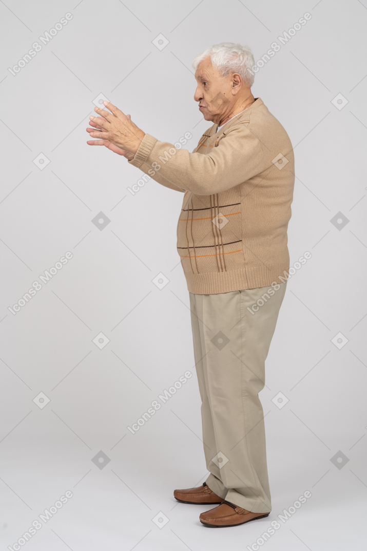 Side view of an old man in casual clothes showing size of something