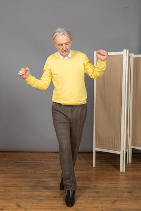 Vista frontal de um homem idoso que anda se equilibrando