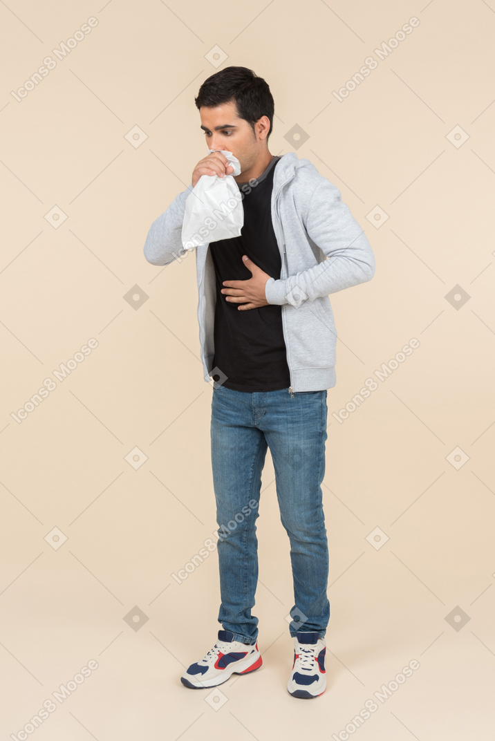 Giovane uomo caucasico che respira in un sacco di carta