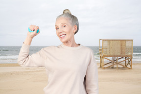 해변에서 운동하는 노인 여성