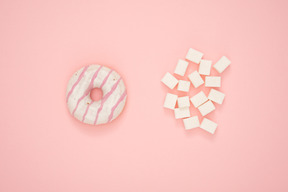 Donut and sugar cubes over pink background