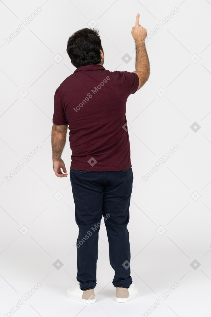 Vista posteriore di un uomo in abbigliamento casual che punta