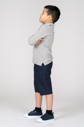 Unhappy boy with crossed arms in profile