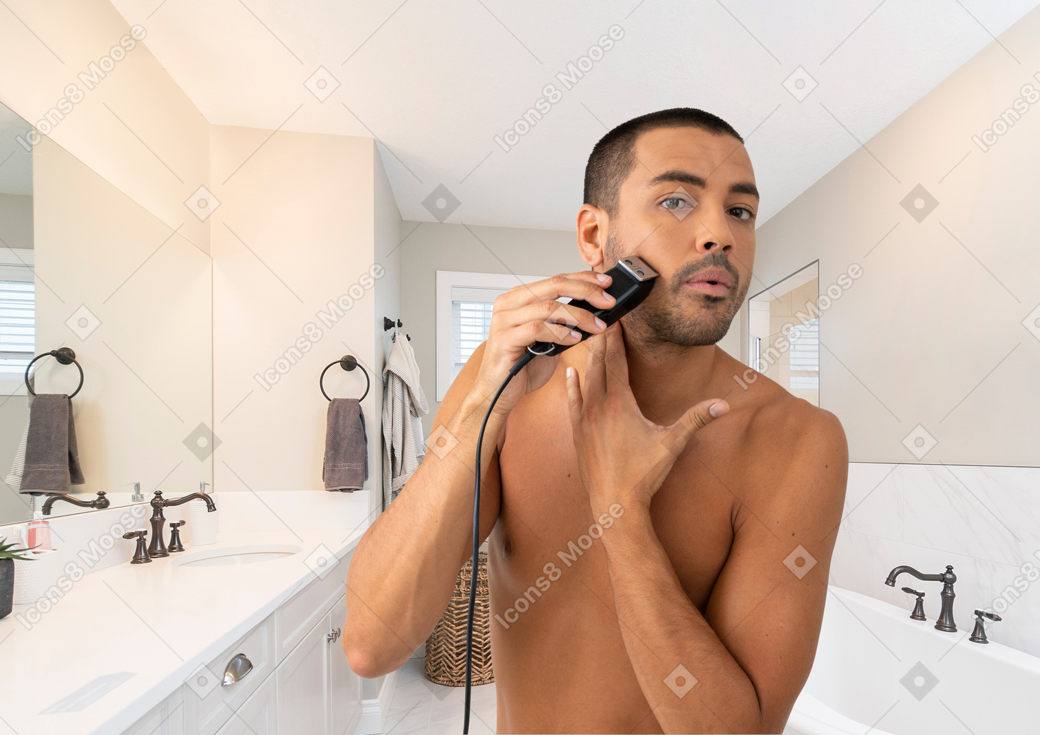A man shaving in a bathroom with an electric razor