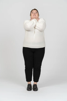 Front view of a plump woman in casual clothes chocking herself